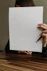 a woman holding a piece of paper and a pencil