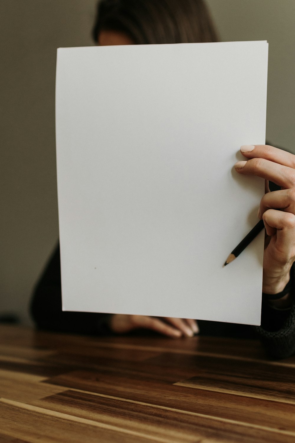 a woman holding a piece of paper and a pencil