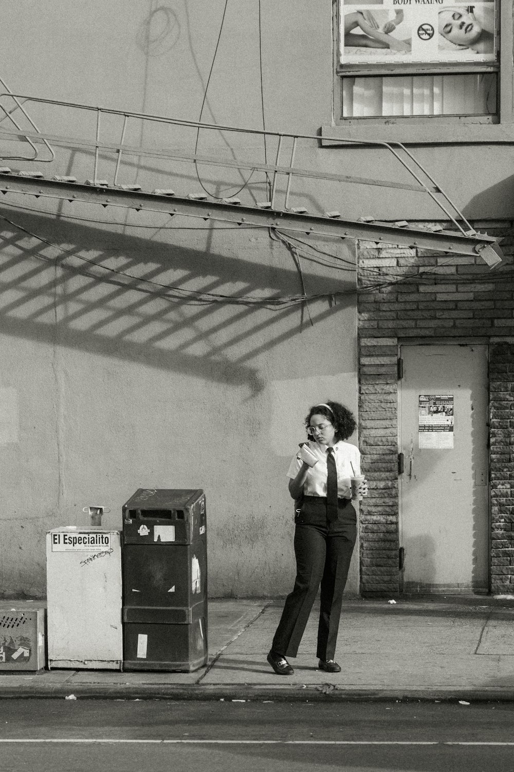 a woman standing on a sidewalk talking on a cell phone