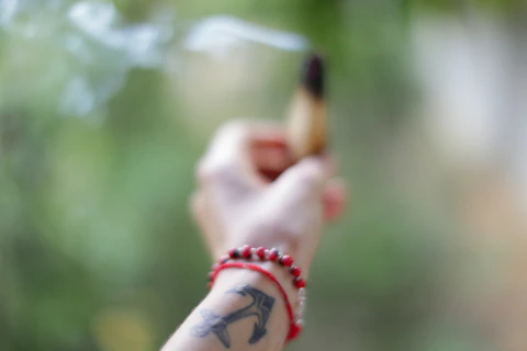 a person holding a cigarette in their hand