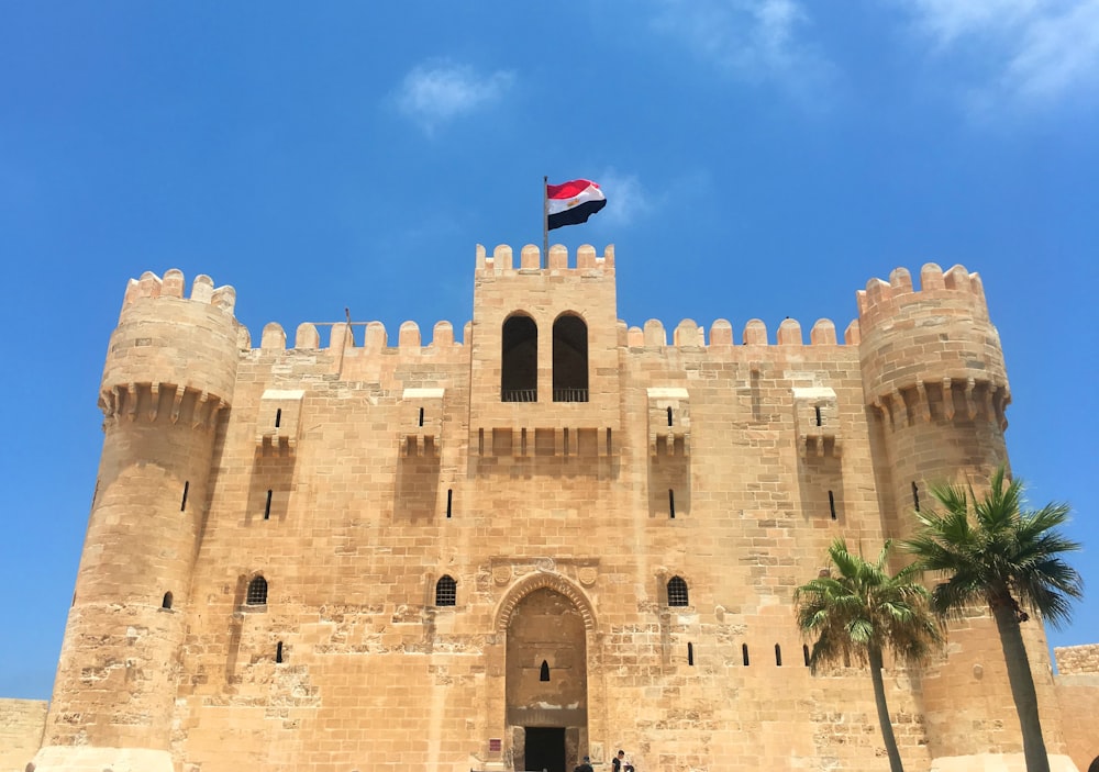 un grand château surmonté d’un drapeau