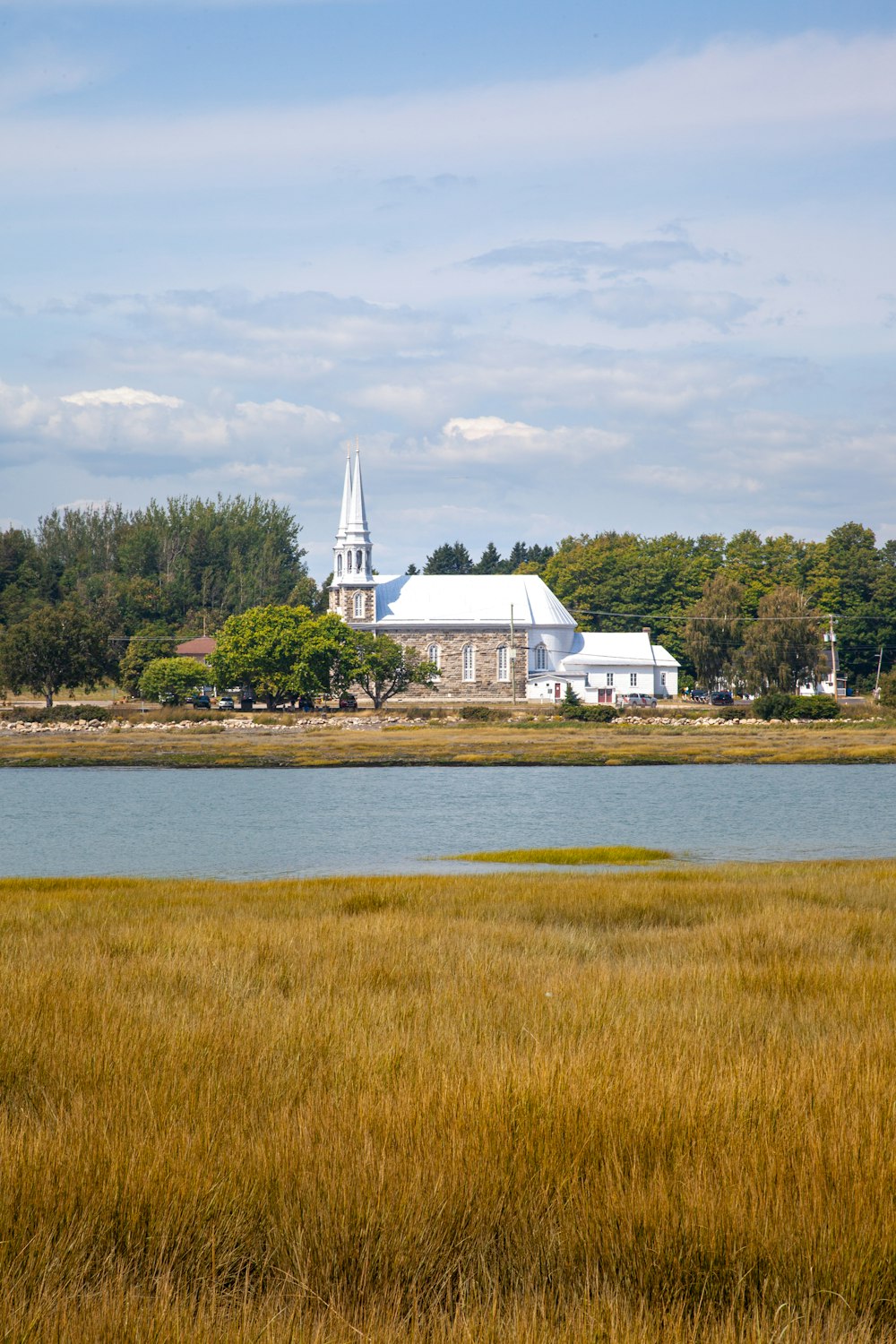 a large white church sitting on top of a lush green field