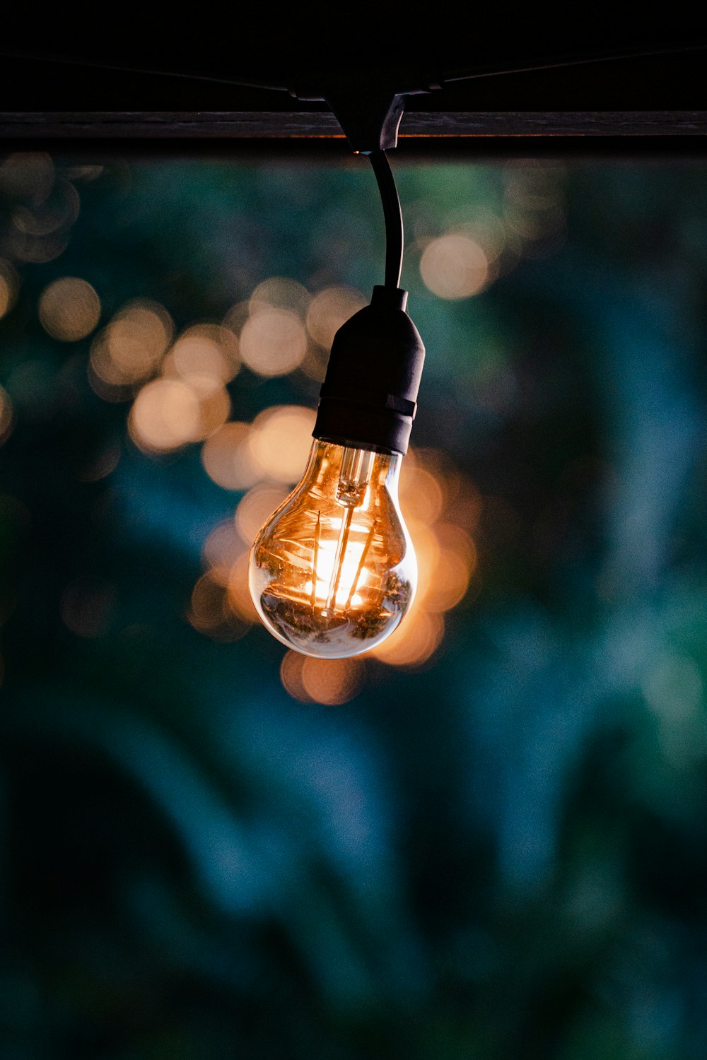 a light bulb hanging from a wire with a blurry background