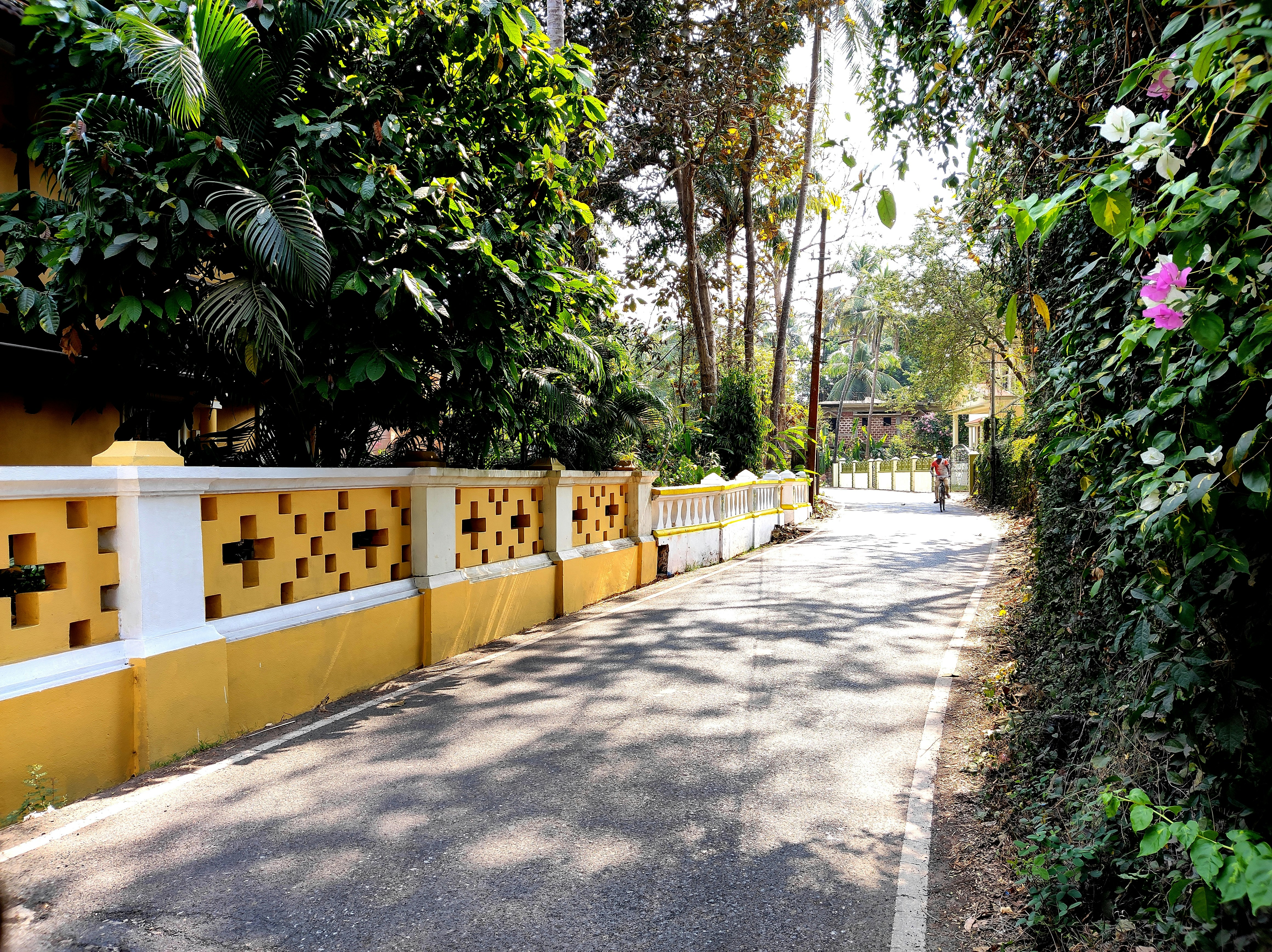 a yellow and white fence next to a road