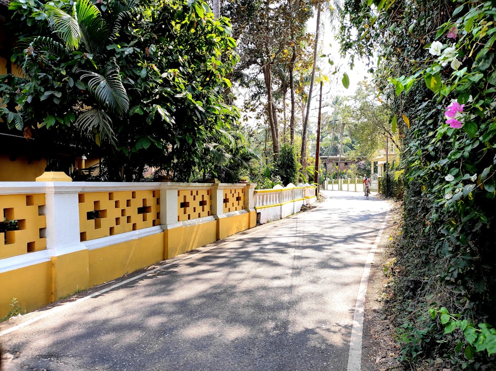 a yellow and white fence next to a road