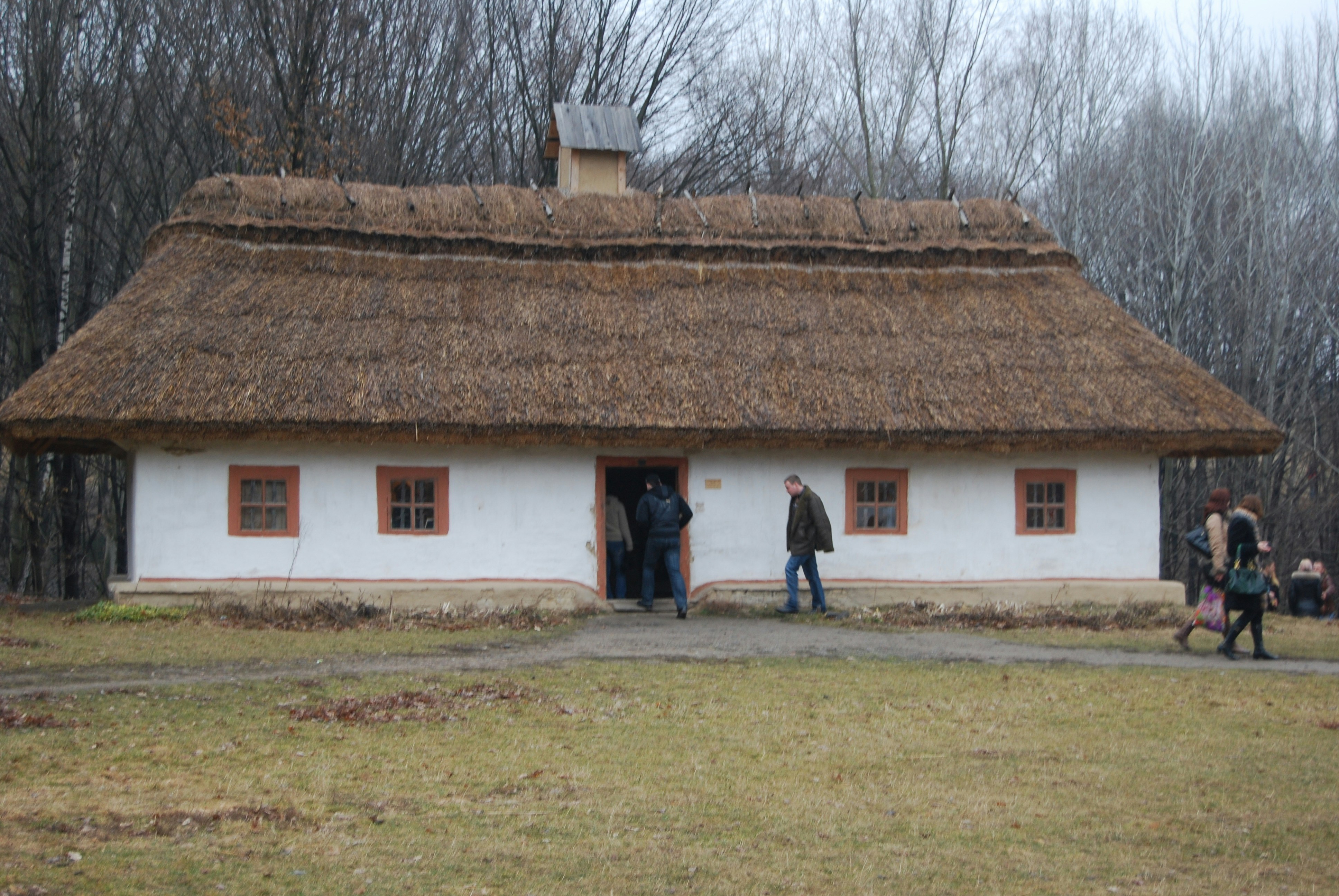 a group of people standing outside of a white house