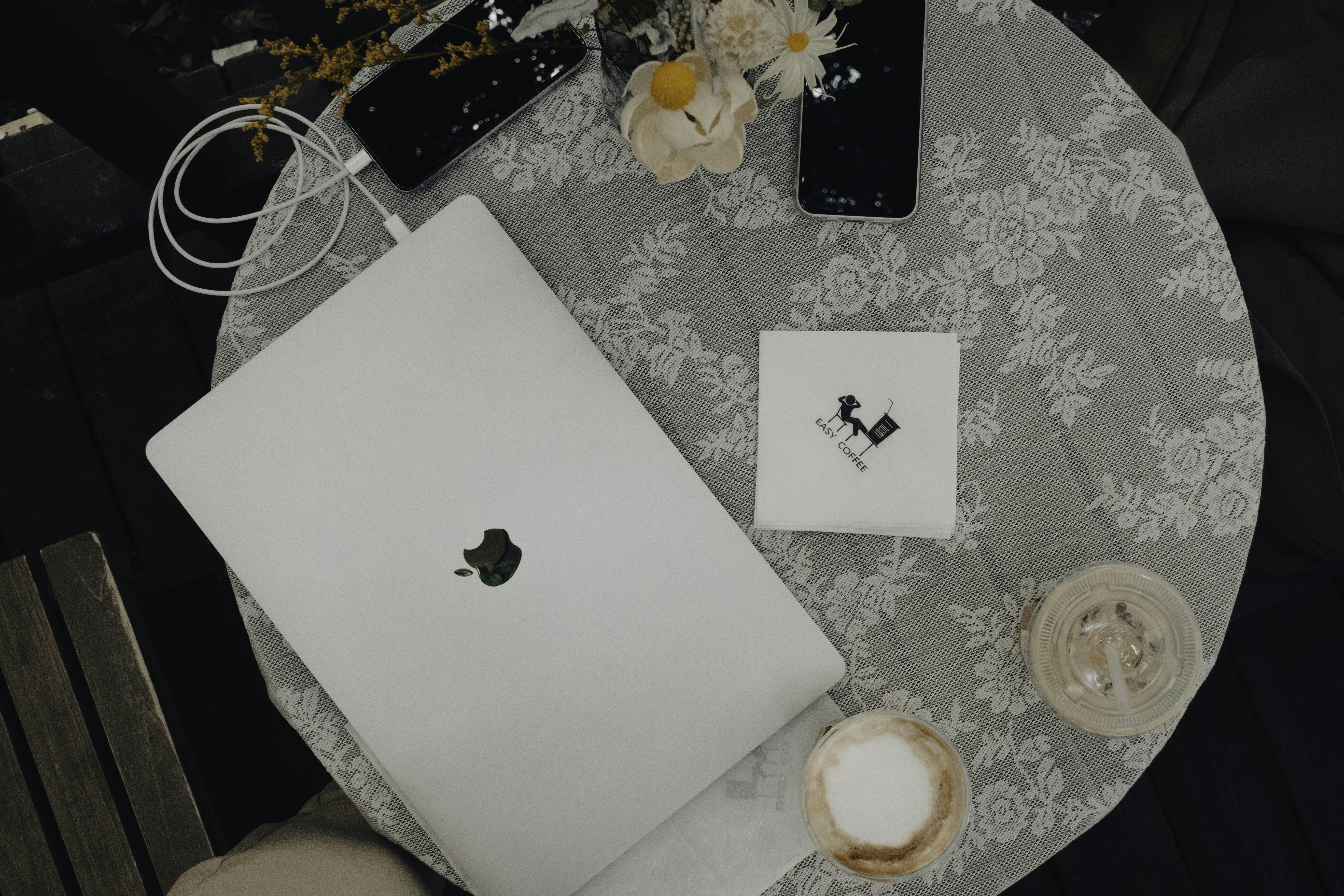 a table topped with a laptop computer next to a cup of coffee