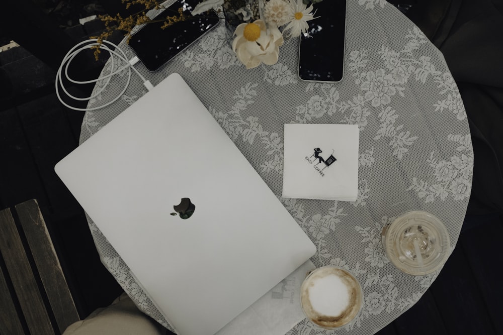 una mesa cubierta con una computadora portátil junto a una taza de café
