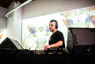 a man in a black shirt is playing a dj set