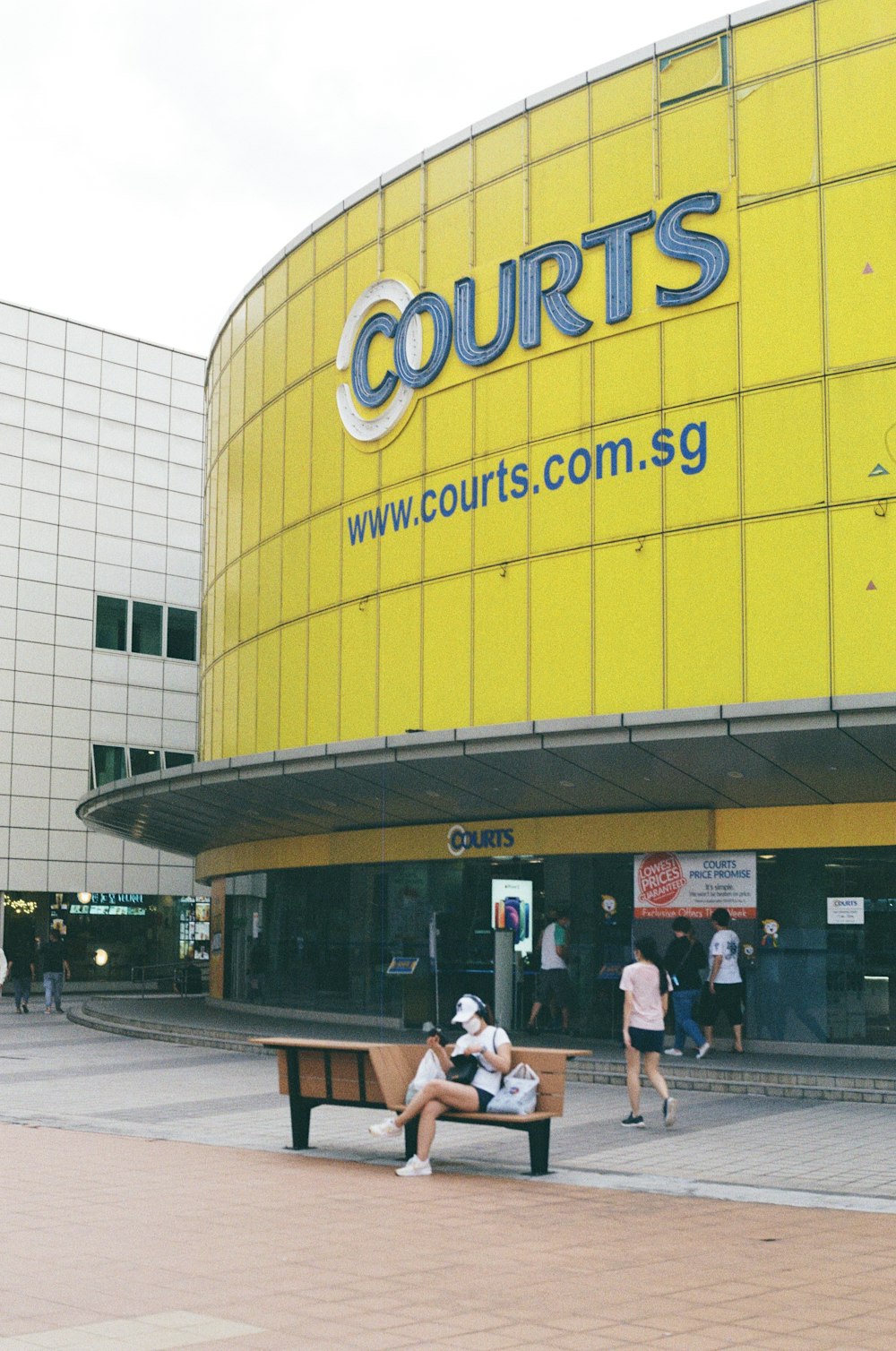 a couple of people sitting on a bench in front of a court