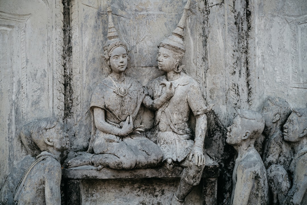 a group of statues of people sitting on a bench