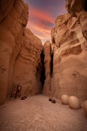 a narrow path between two large rocks in the desert