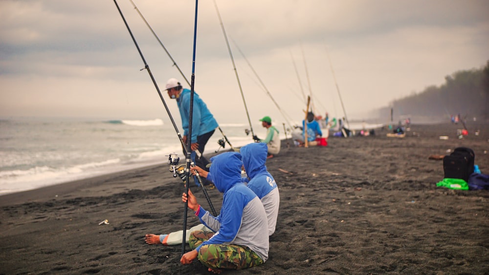 a group of people fishing on the beach