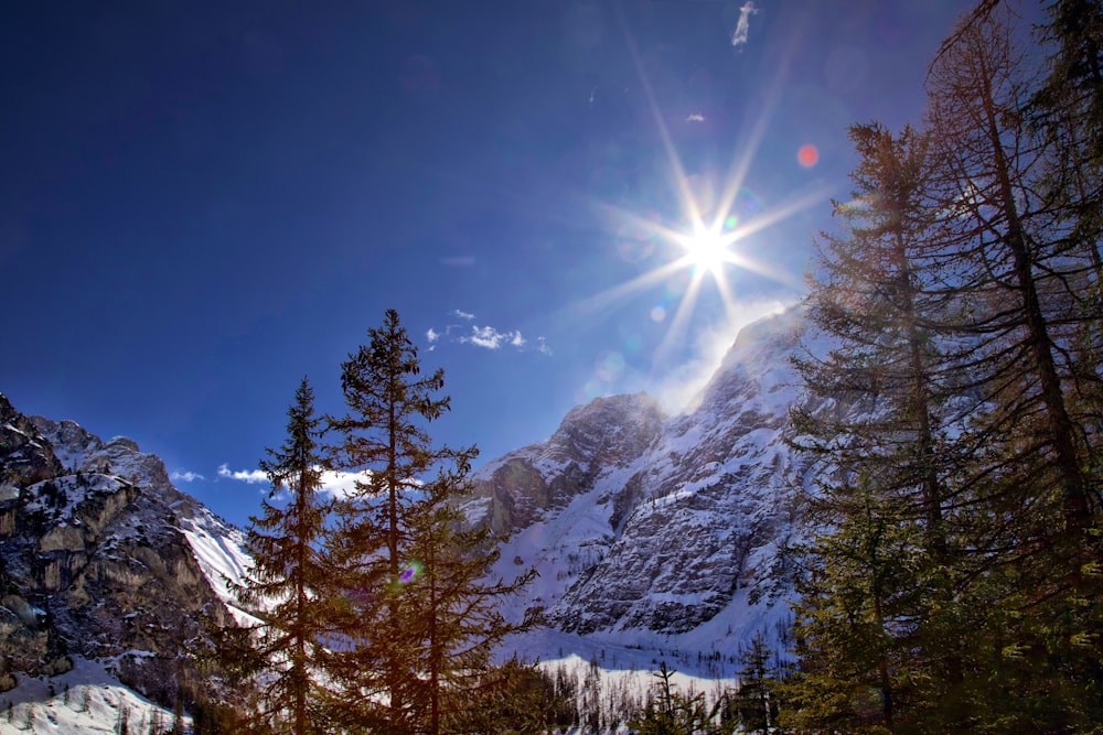 the sun shines brightly over a snowy mountain