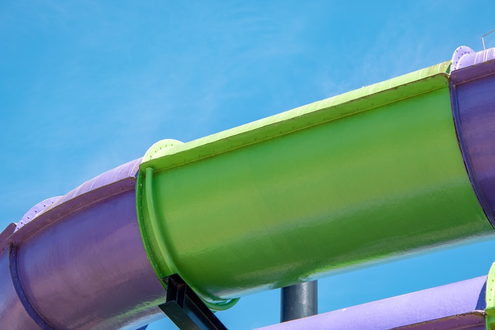 a green and purple slide against a blue sky