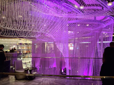 Luxurious VIP table bathed in neon purple and gold lighting with plush seating.