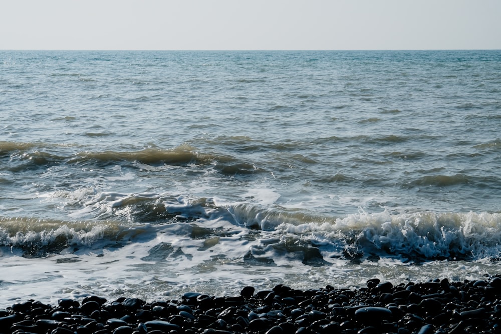 a body of water sitting next to a rocky beach