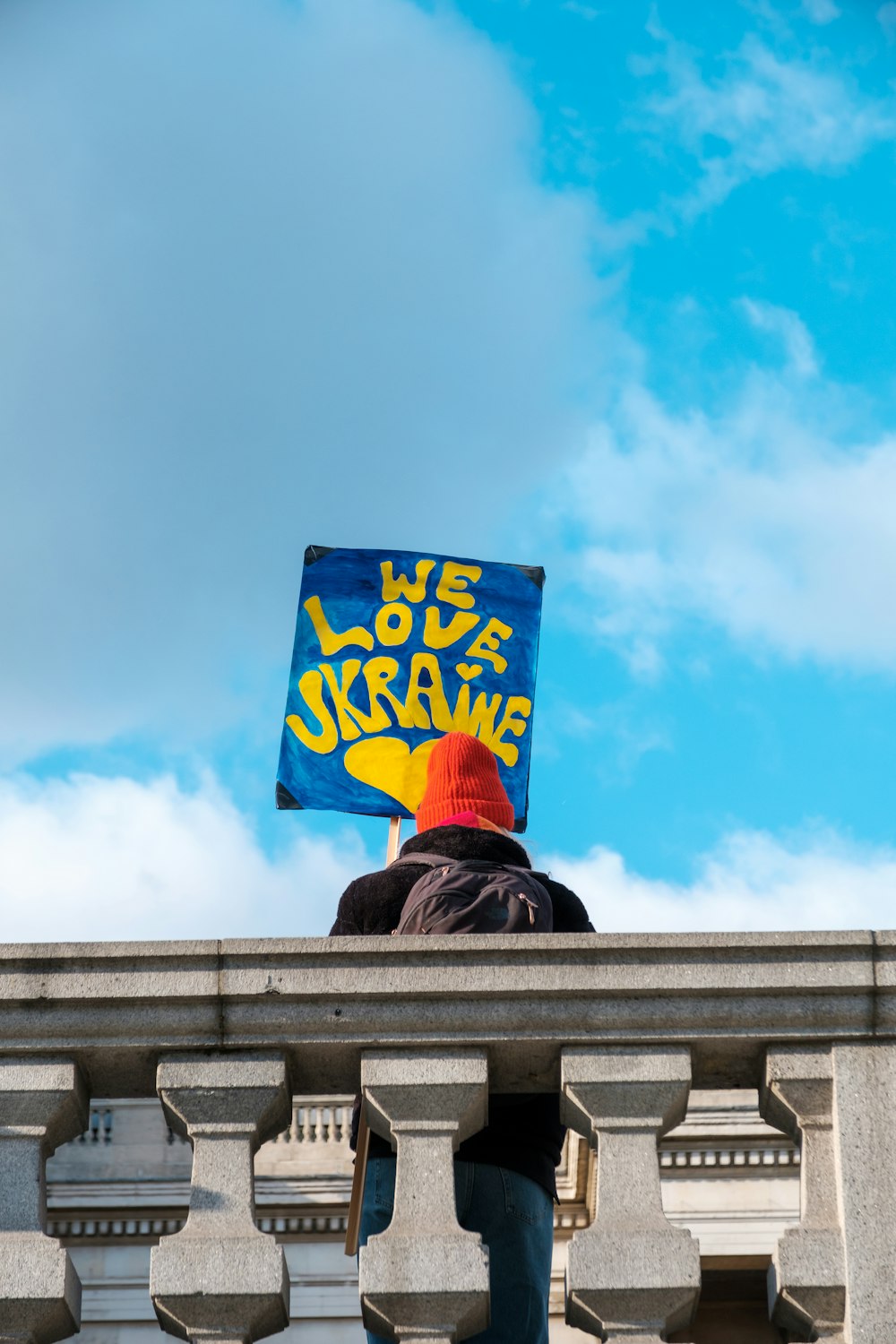 a person holding a sign on top of a building