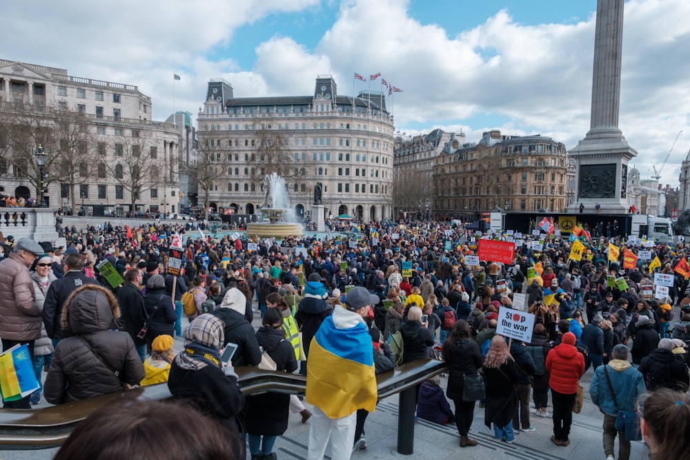 a large crowd of people standing around a fountain