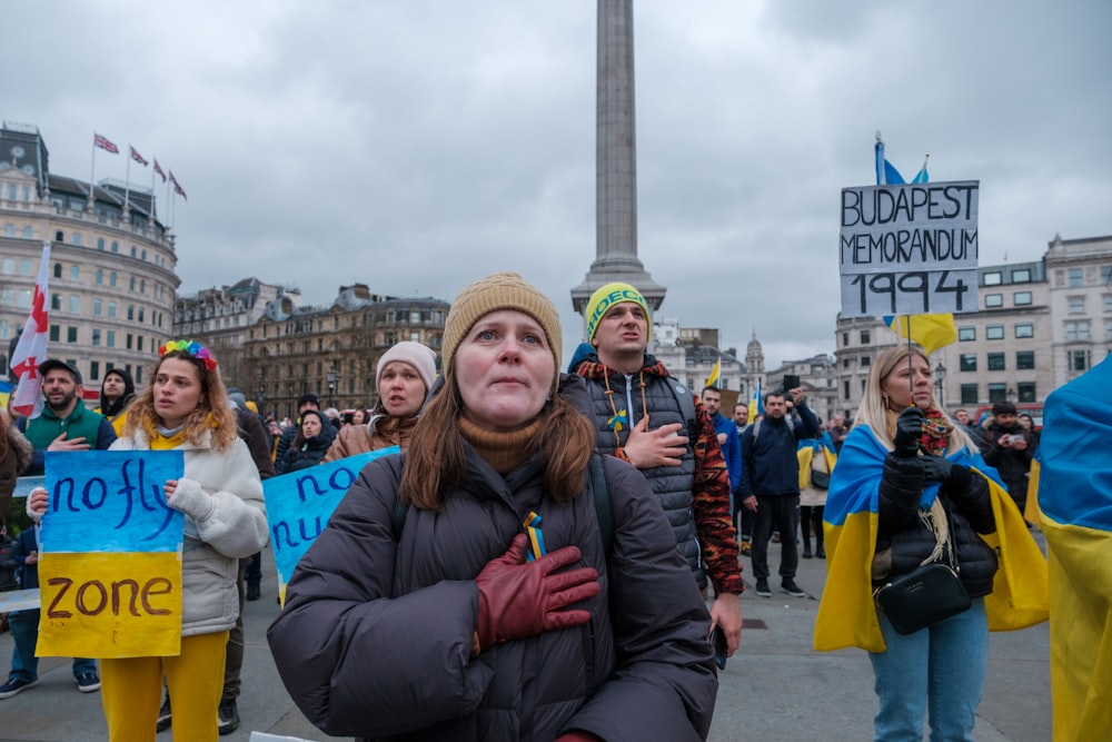 a group of people standing around holding signs