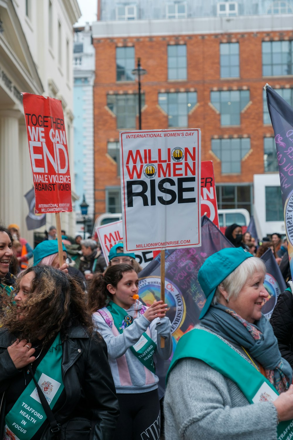 a crowd of people holding signs and flags