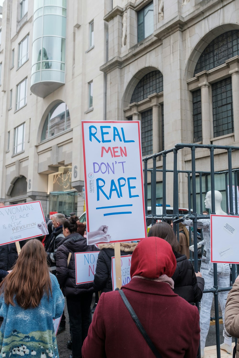 a group of people holding signs in front of a building