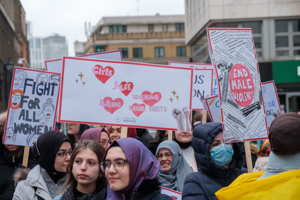 a group of people holding up signs in the street