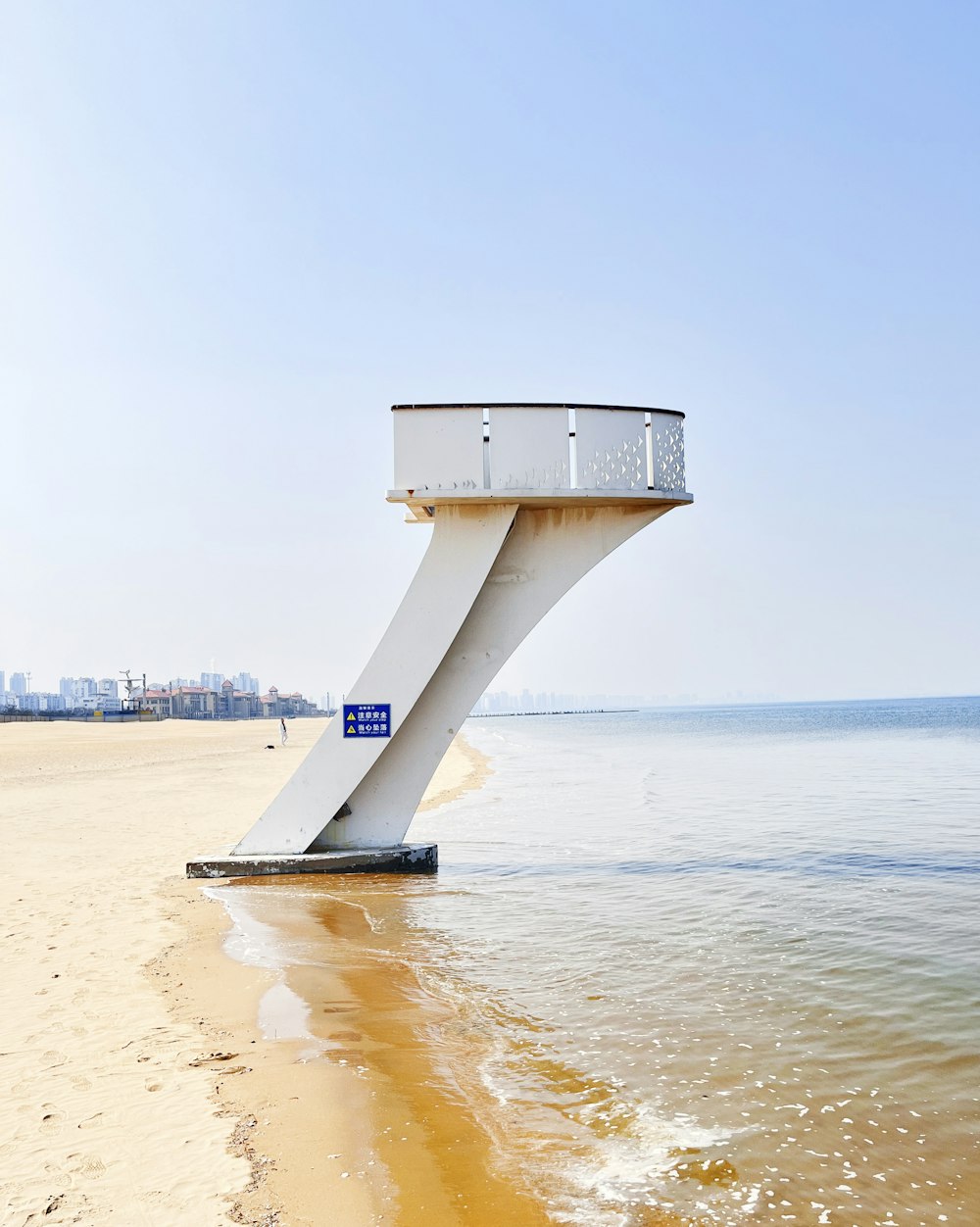 a large white structure sitting on top of a sandy beach