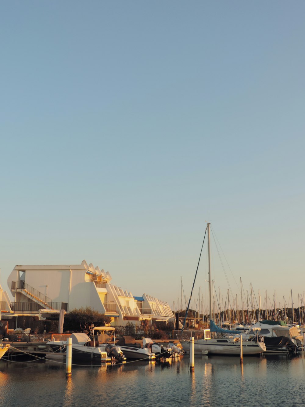 a marina filled with lots of boats under a blue sky