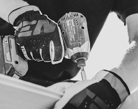 a person using a drill gun on a piece of wood