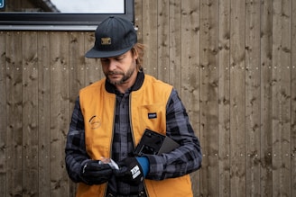 a man wearing a hat and holding a cell phone