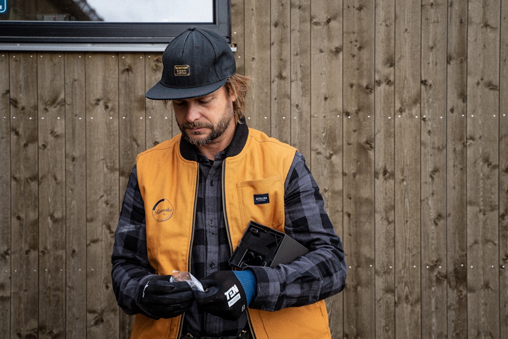 a man wearing a hat and holding a cell phone