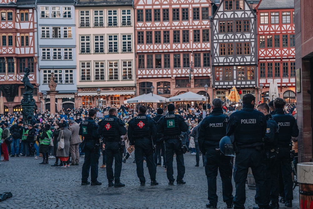 a group of police officers standing in front of a crowd of people