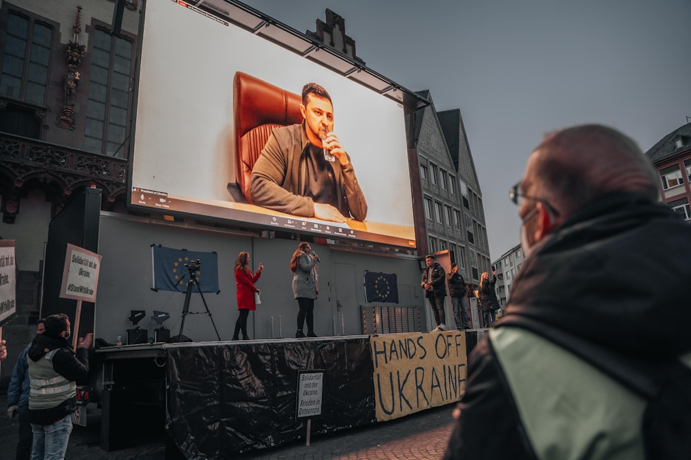 Un homme debout devant un grand écran