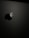 A sleek, minimalist design featuring a prominent, glossy apple logo against a matte dark background. The logo has a distinctive bite mark and is illuminated softly, creating a subtle reflection.
