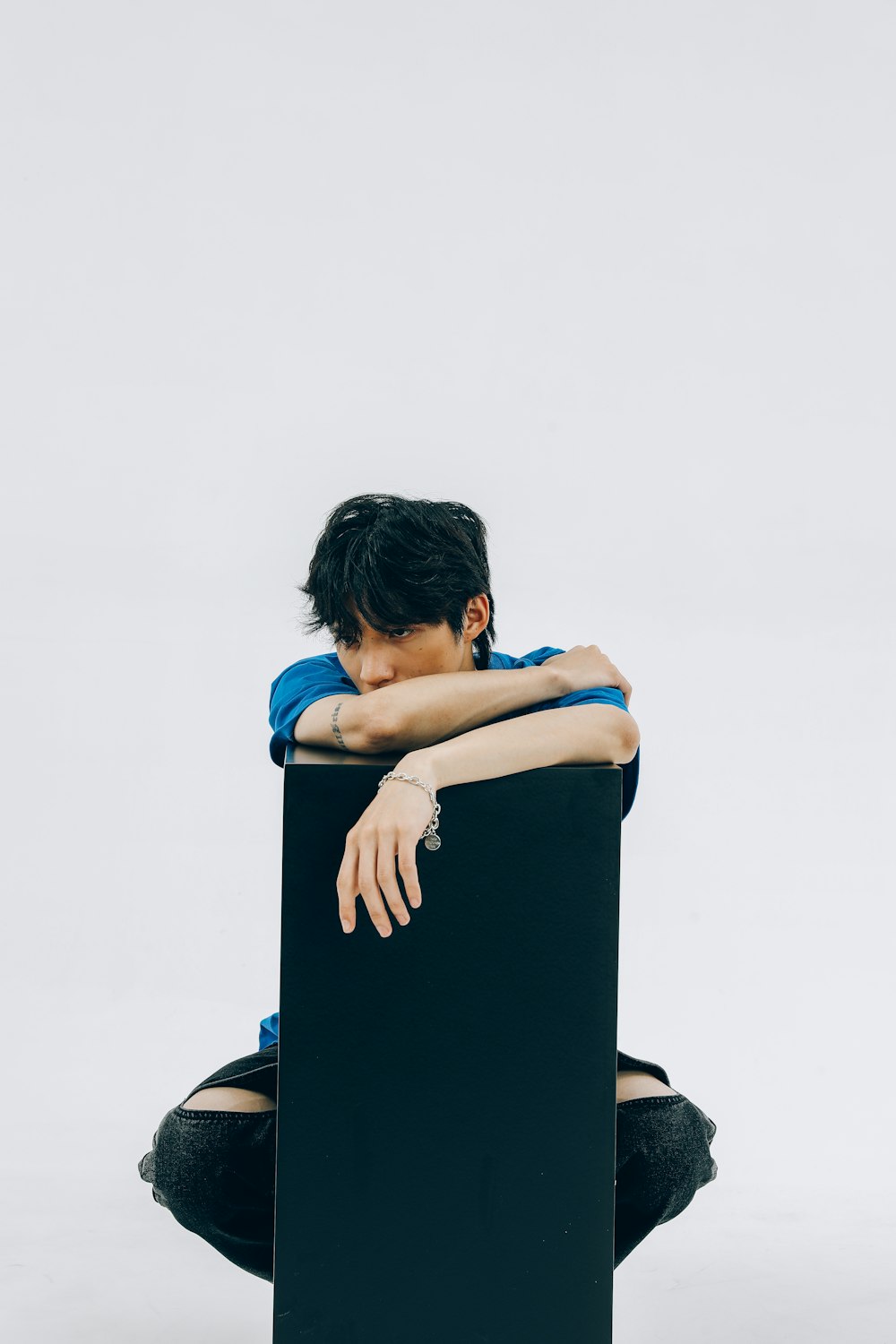 a person sitting in a chair with their head on their hands