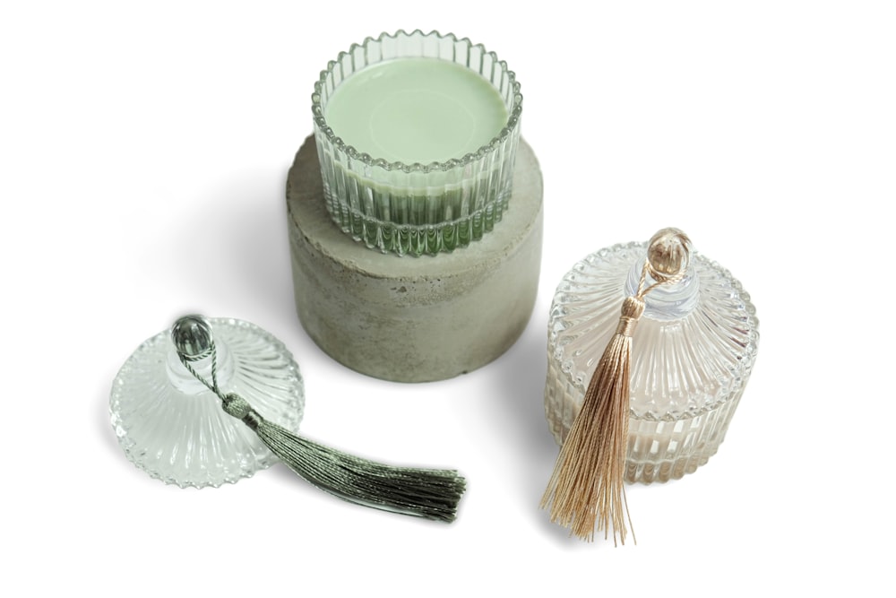a glass container with a tassel and a small glass container with a tassel