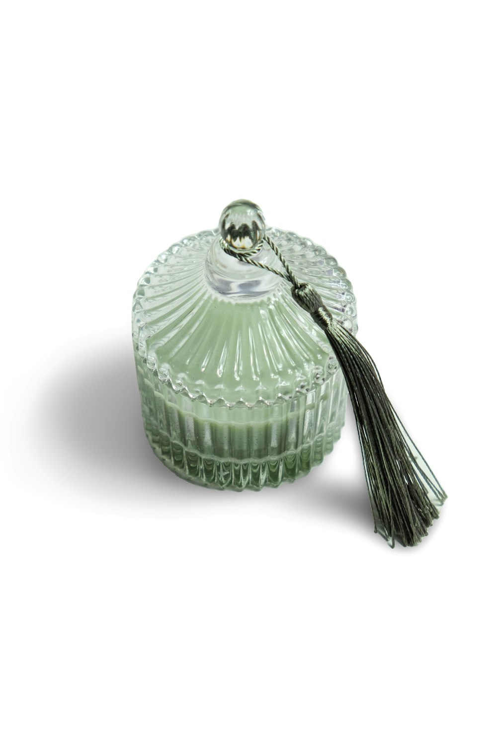 a glass dish with a tassel on top of it