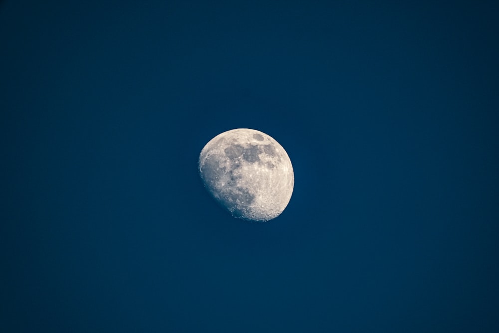 a full moon in a blue sky with no clouds