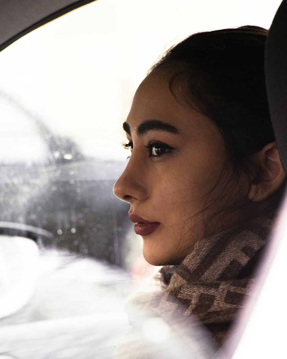 a woman sitting in a car looking out the window