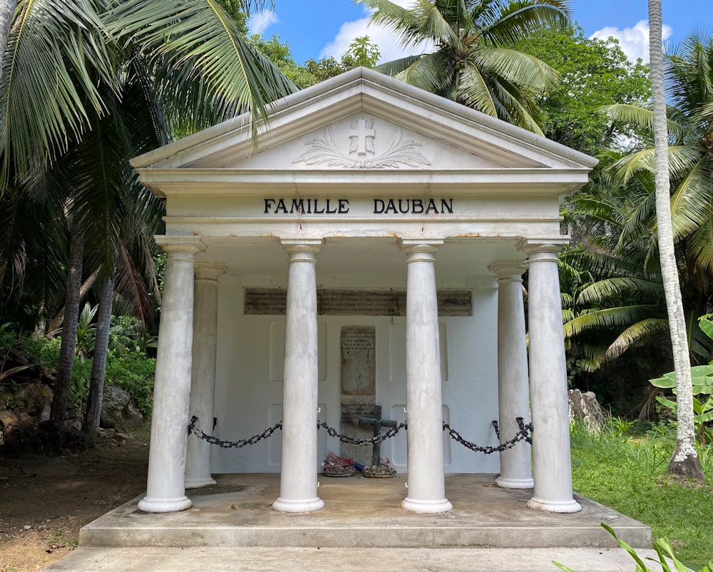 a white building with pillars and a sign on it