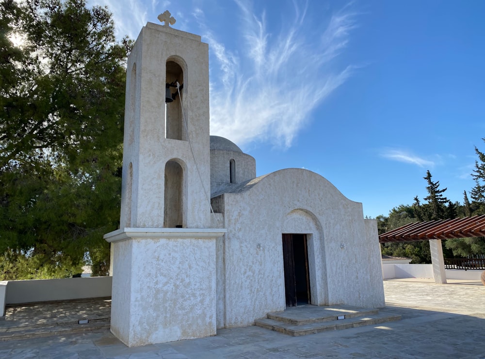 uma igreja branca com uma torre sineira em um dia ensolarado
