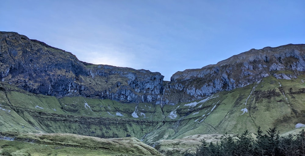 a view of a mountain range with trees in the foreground