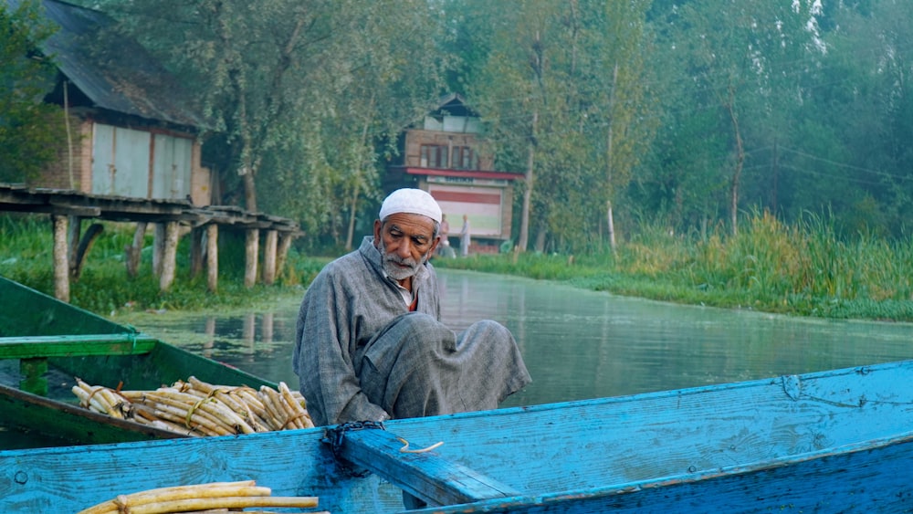 a man sitting in a blue boat on a river