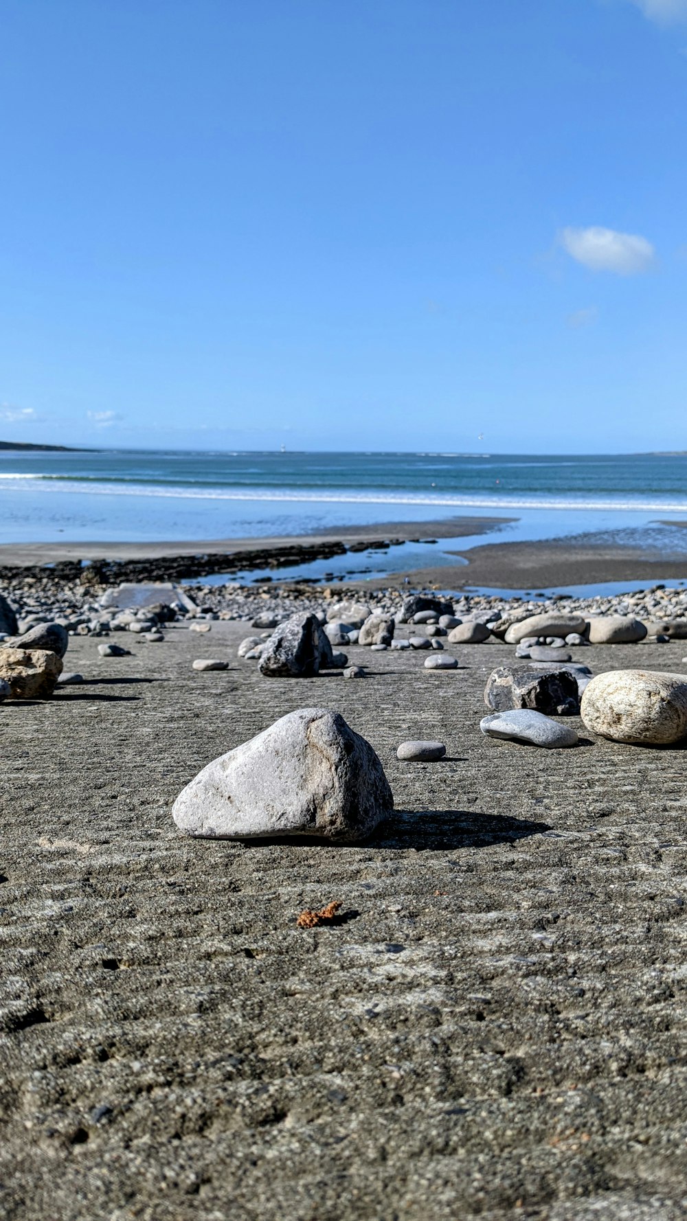 un tas de rochers assis au sommet d’une plage de sable