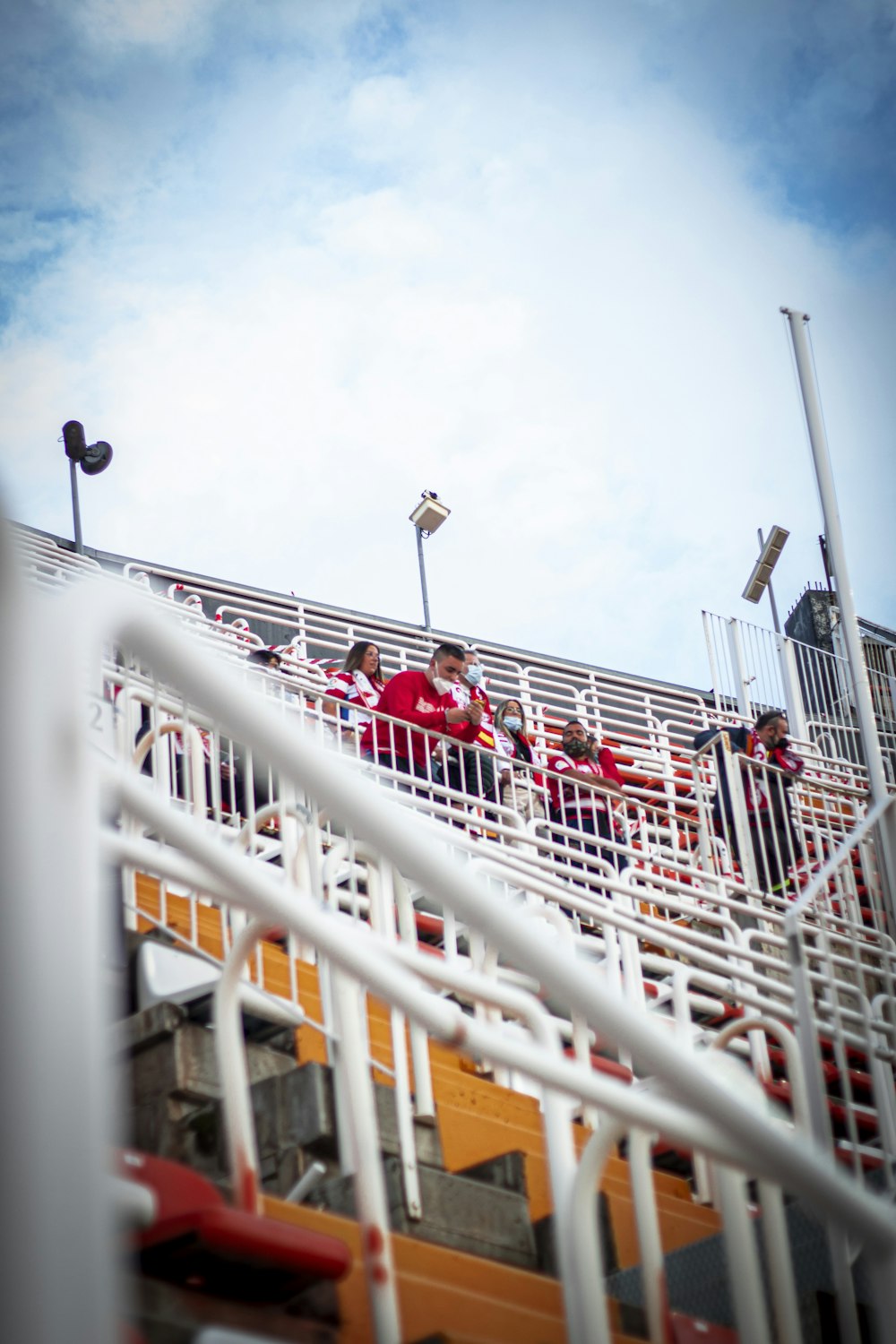 a group of people sitting on top of a bleachers