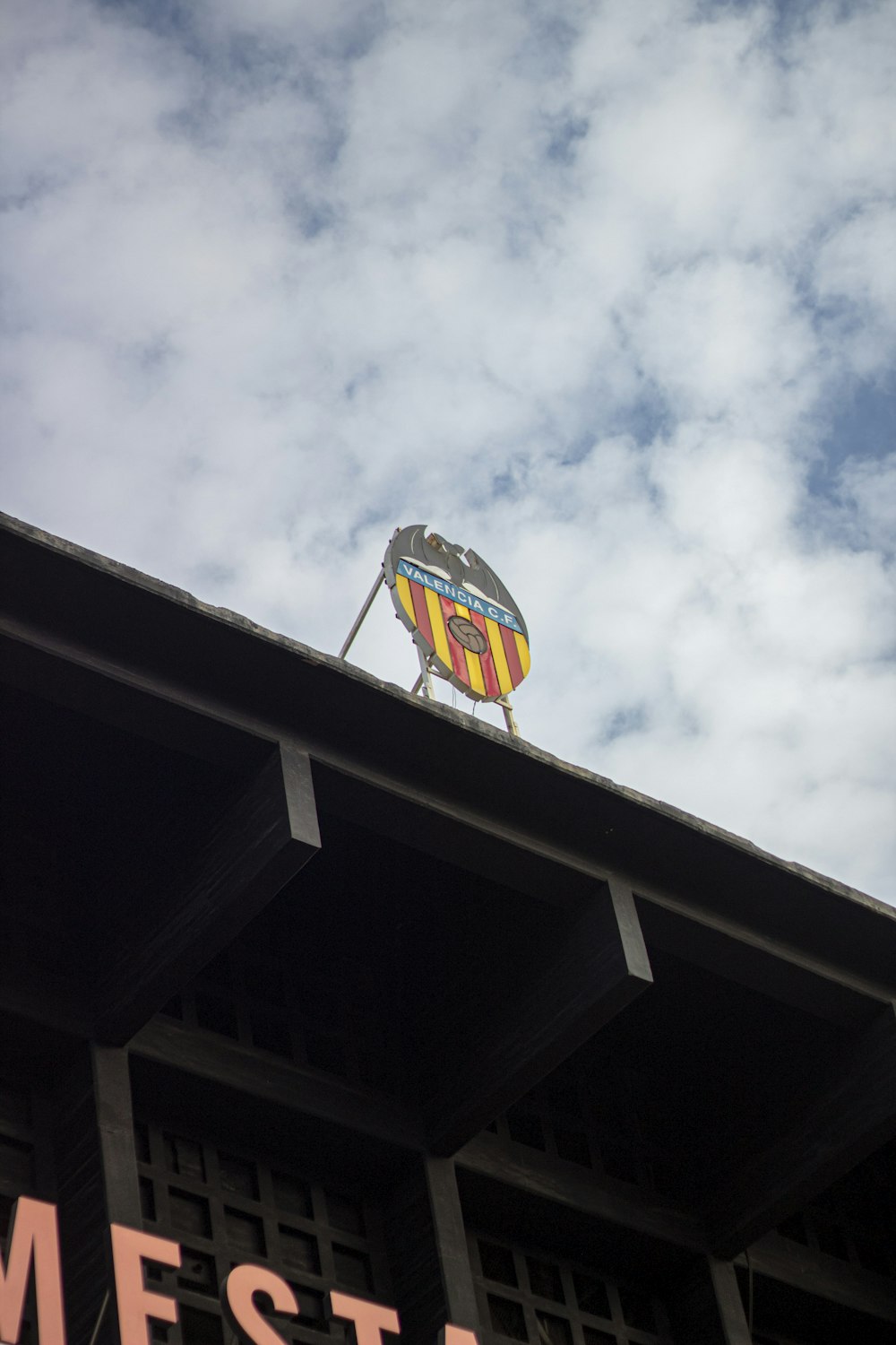 uma bandeira no topo de um edifício com um fundo do céu