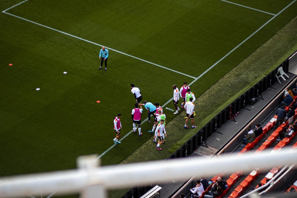 a group of people standing on top of a soccer field