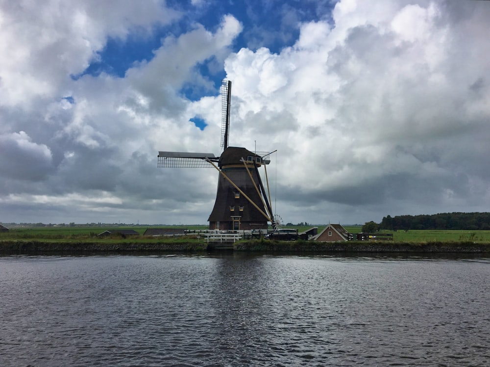 Un gran molino de viento sentado al lado de un río