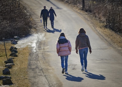 a couple of people walking down a dirt road